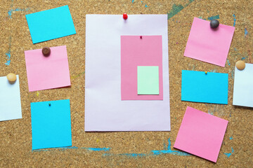 Different colorful notes on old cork board. Free space for text or images