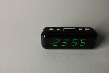 Digital alarm clock showing 23:55 o'clock on grey background, space for text