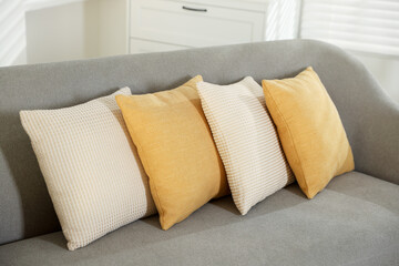 Soft decorative pillows on sofa in room