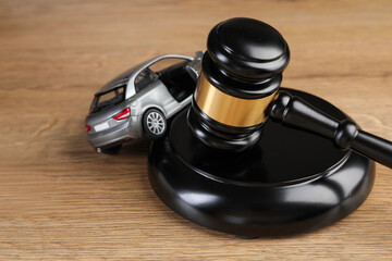 Motor vehicle accident law. Gavel and car model on wooden background, closeup