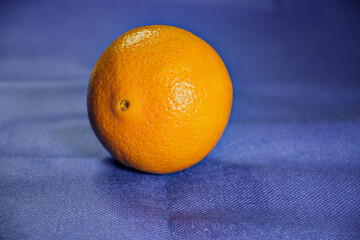Fresh, juicy orange citrus fruit isolated on a vibrant blue background