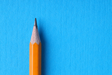 One pencil on light blue background, top view. Space for text