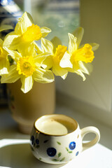 Coffee and daffodils in a beautiful morning moment