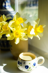 Coffee and daffodils in a beautiful morning moment