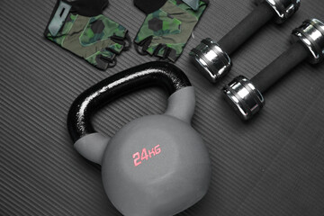 Kettlebell and other sports equipment on fitness mat, flat lay