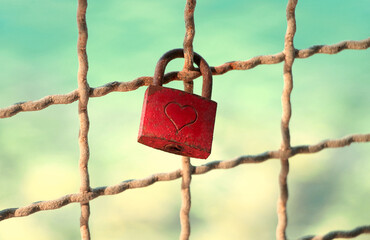 Red padlock with heart on the fence