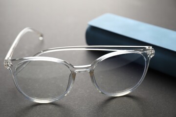 Case with stylish glasses on gray background, closeup