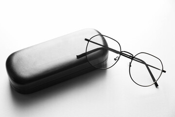 Case with stylish glasses on light background, closeup