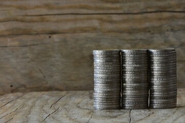 Stacked coins into three columns on wooden background concept of money economics copy space