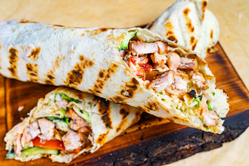 Cut in half kebab with meat filling on a wooden board