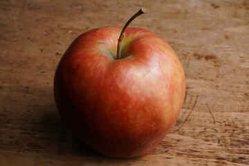 Bright red apple displayed on rustic wooden table