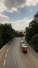 A tram travels along a winding road in Prague, Czech Republic.