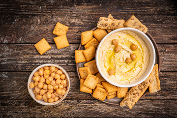 Various hummus dips in different colours. Hummus with dry crackers, top view. Vegan and traditional hummus as healthy and vegan snack.