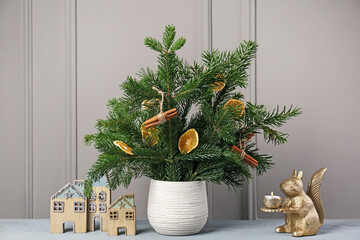 Beautiful Christmas composition of decorated fir tree branches on gray wooden table near indoors