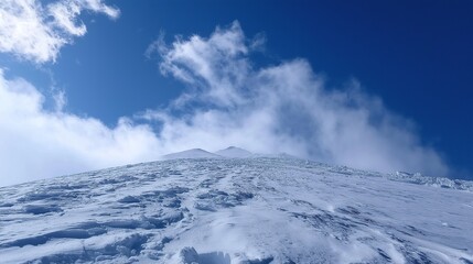 Captivating view of Mount Fuji's snow-clad summit piercing through cotton-like cloud layers under brilliant daylight. Low-angle perspective showcasing volcanic slopes and atmospheric depth in Japan.