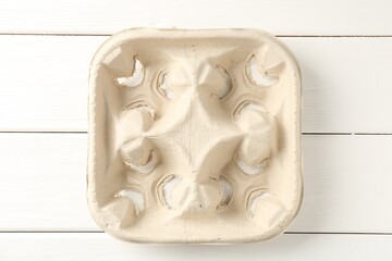 Empty cardboard cup holder on white wooden table, top view