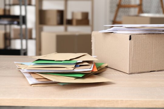 Many different envelopes and parcel on table in post office. Space for text
