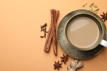 Aromatic Masala tea in cup and spices on beige background, flat lay. Space for text