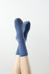 Woman in blue socks on light background, closeup