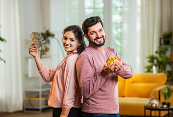 Confused man with jewelry, wife surprises with money fan — celebrating gold loan approval