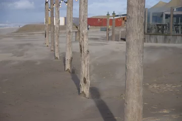 Gordijnen Beach with sand and poles at the Noordwijk promonade © André Muller