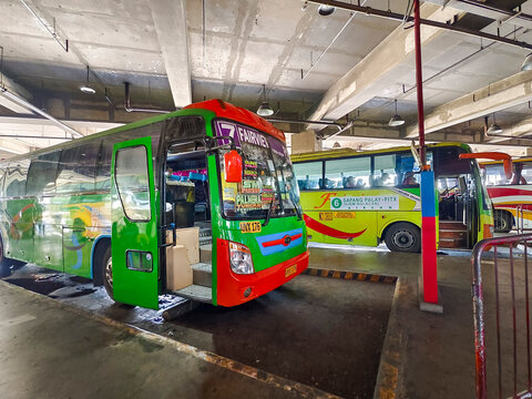 Paranaque, Metro Manila - Provincial and city buses including Fairview and San Jose del Monte routes idle at PITX terminal's ground-level bus bay.