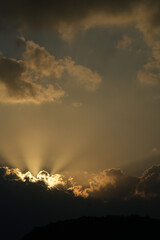 雲の裏から光が射す夜明けの空