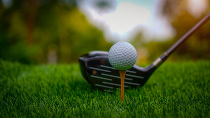 Golf clubs and balls on a green lawn in a beautiful golf course with morning sunshine.