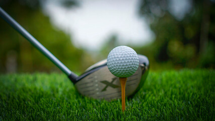 Golf clubs and balls on a green lawn in a beautiful golf course with morning sunshine.