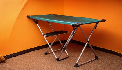 温かなオレンジの背景に溶け込む折りたたみテーブルが、キャンプの一瞬一瞬を楽しむための準備として静かに佇んでいる

