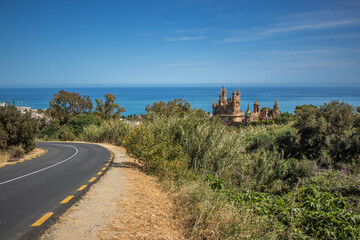 Spanish Landscape of Castillo de Colomares with Curved Asphalt Road and Sea in Costa del Sol. Beautiful Scenery in Benalm&aacute;dena during Sunny Day in Spain.
