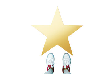 Feet of a person in sneakers standing before a gold star on white background, isolated closeup...
