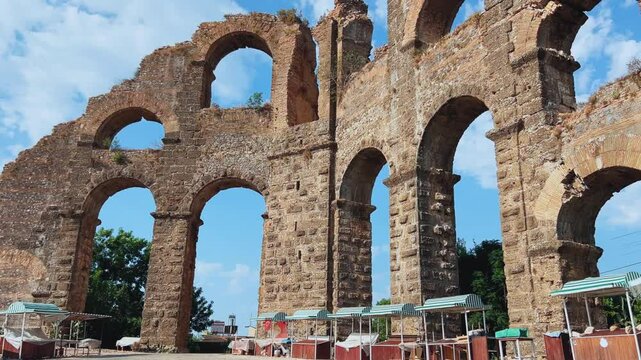 The ancient city of Aspendos. Ruins of aqueducts of Aspendos Acropolis. T&uuml;rkiye. Historical siphon of Aspendos Aqueduct with olive trees, Antalya. 4K