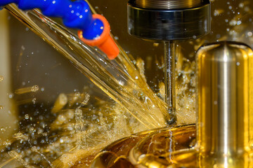 Close up scene the CNC milling machine finishing cut the brass shell mold parts with oil coolant...