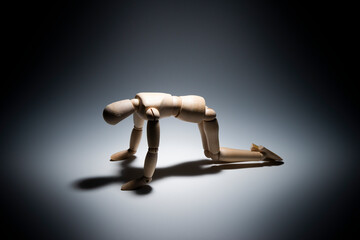 スポットライトのなかでがっくりするデッサン人形