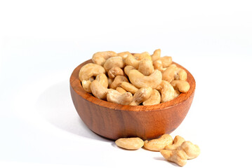 Cashewkerne und Holzschale vor weißem Hintergrund
