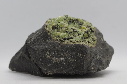 Olivine in a rock isolated on a white background. Olivine isolated on a white background