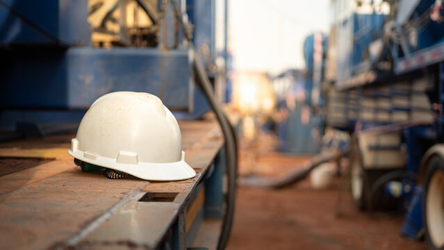 A white safety helmet or protective hardhat is placed at the construction site. Industrial safety PPE object, ready to working at unsafe workplace concept. Close-up.