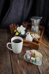 Traditional Turkish delight food background. Assorted. Sweet delicious lukum and white coffee cup on wooden table