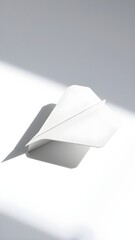 An intricately folded paper airplane, on a white surface