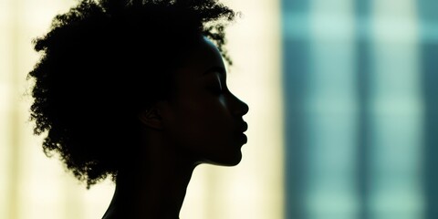 Silhouette of a Young Black Woman with Curly Hair Against a Teal and Beige Background