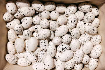 Speckled white decorative eggs in a box.