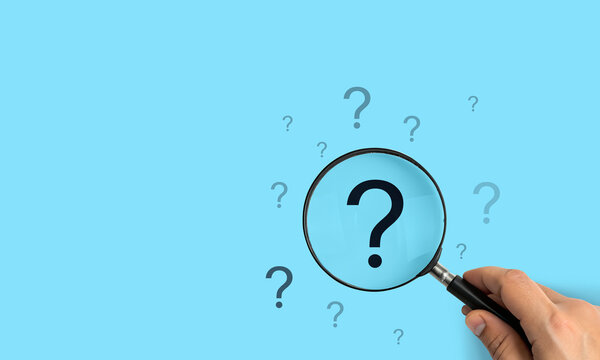 Focusing on a large question mark, A hand holding a magnifying glass over a large question mark