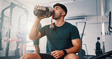 Break, drinking water and exercise with man in gym for fitness, training or workout routine. Bottle, hydration and performance with thirsty athlete in health club for physical improvement or recovery