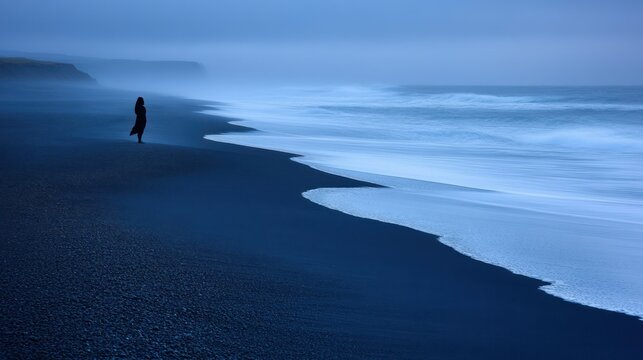 Solitude by the Ocean: A Woman Silhouetted Against the Misty Icelandic Coast