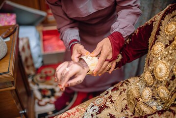 Close-up of a bride's hand adorned with intricate henna designs, symbolizing beauty and tradition...