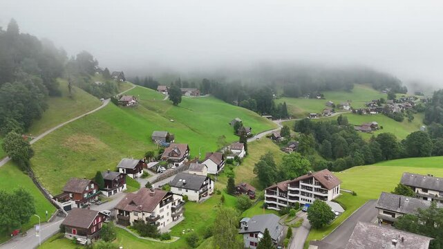 7 juli 2025, Wildhaus-Alt Sint Johann, Switzerland. Drone flight above the village centre of Wildhaus, a charming village near the Alpstein mountain range. Small alpine town centre, houses. Surrounded