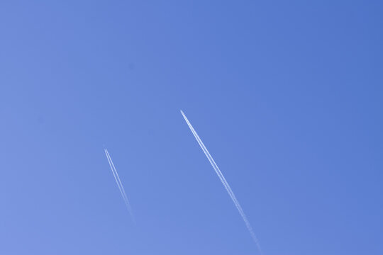 blue sky with two airplane contrails, airplane contrails, double white stripes in the sky, sunny day