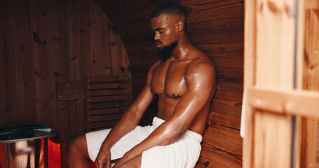 Sauna, fitness and relax with black man in gym for muscle recovery, post workout and health. Detox...
