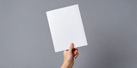 A hand outstretched with a blank white sheet on a white background